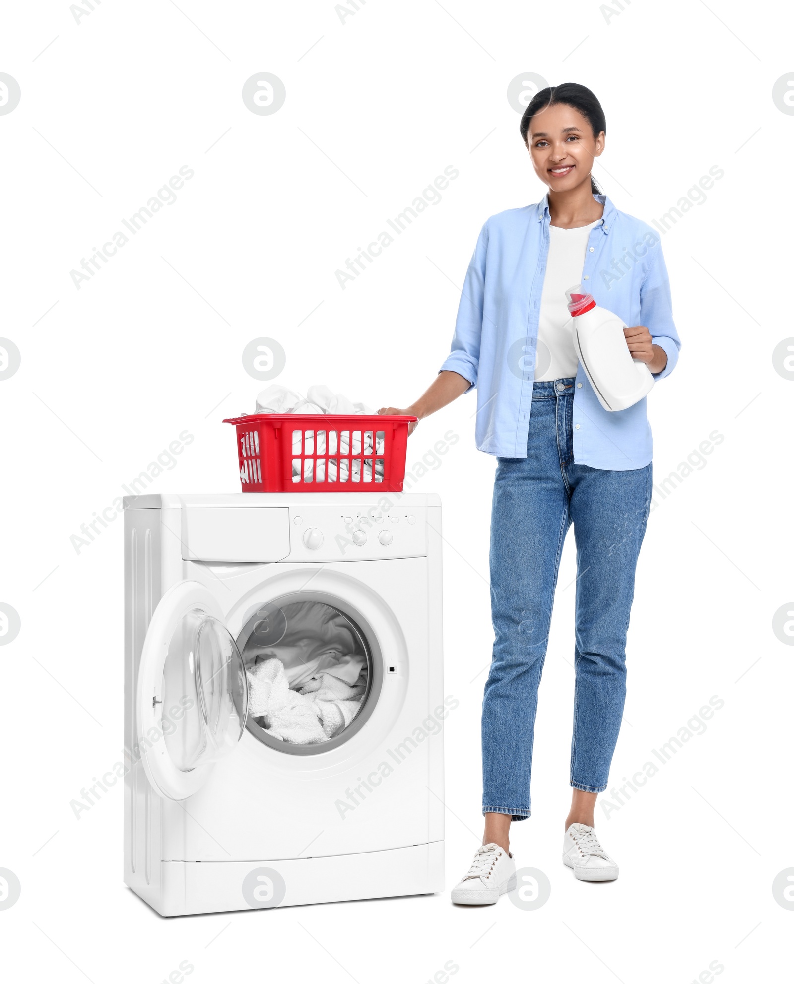 Photo of Beautiful woman with detergent and laundry basket near washing machine on white background