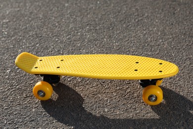 Photo of Stylish yellow skate board on asphalt outdoors