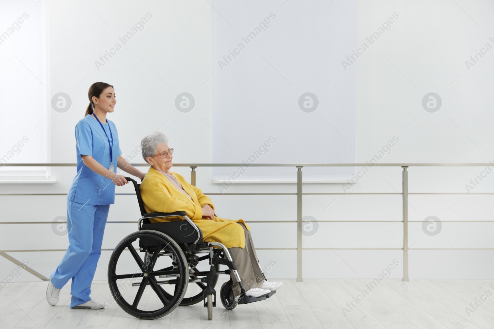 Photo of Nurse assisting senior woman in wheelchair at hospital