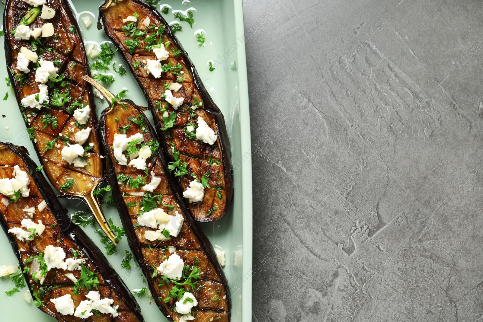 Photo of Baking dish with fried eggplant slices on grey background, top view. Space for text