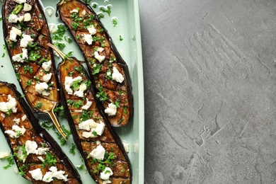 Baking dish with fried eggplant slices on grey background, top view. Space for text