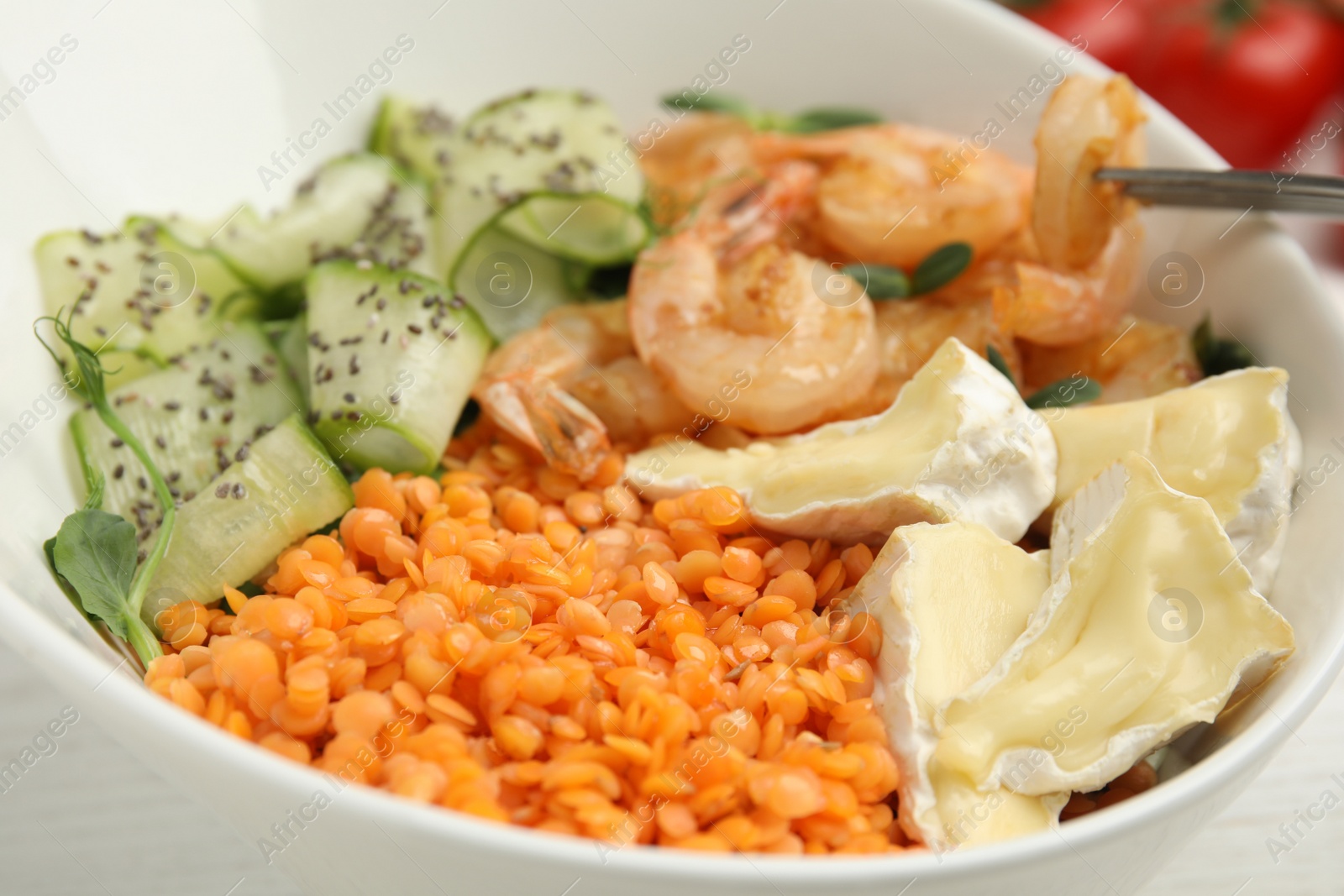 Photo of Delicious lentil bowl with shrimps, soft cheese and cucumber, closeup