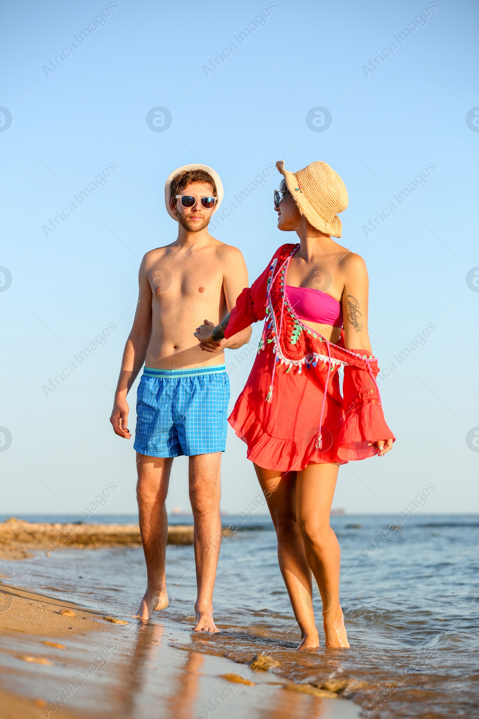 Photo of Happy young couple walking together on beach