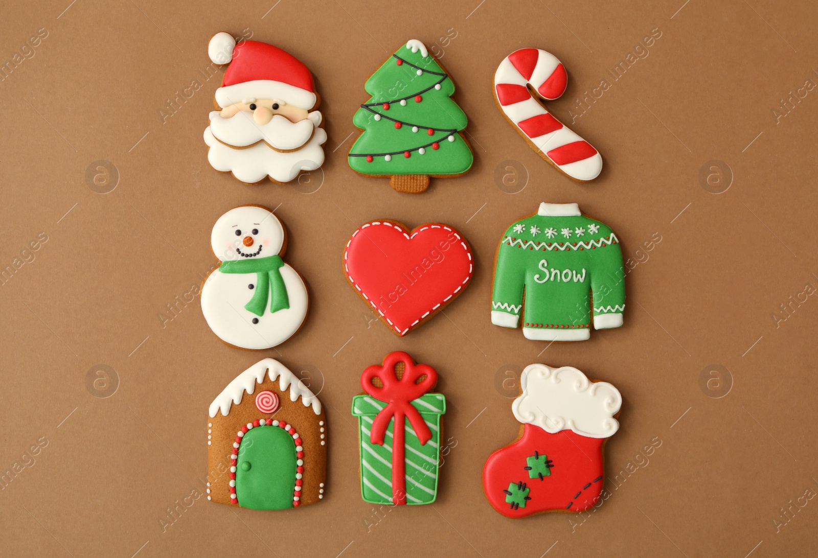 Photo of Different Christmas gingerbread cookies on brown background, flat lay