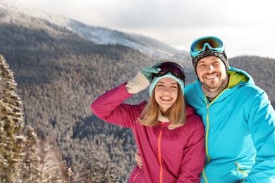 Happy couple spending winter vacation in mountains