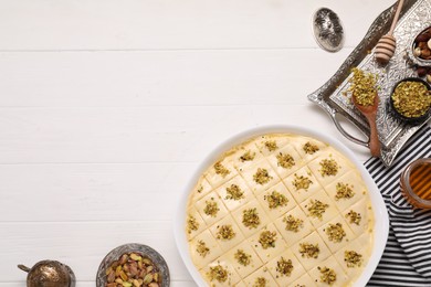 Photo of Making delicious baklava. Raw dough with ingredients on white wooden table, flat lay and space for text