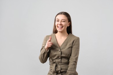 Photo of Portrait of happy young woman on light grey background. Personality concept