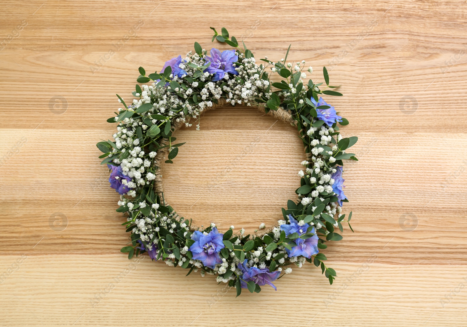 Photo of Beautiful flower wreath on wooden background, top view