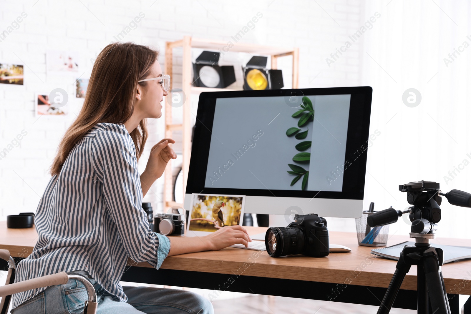 Photo of Professional photographer working at table in office