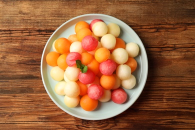 Melon and watermelon balls with mint on wooden table, top view