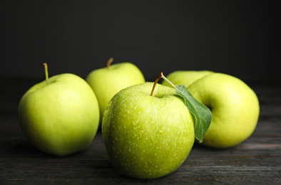 Fresh ripe green apples on black wooden table, space for text