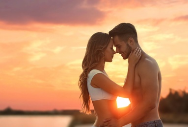 Happy young couple in beachwear outdoors at sunset