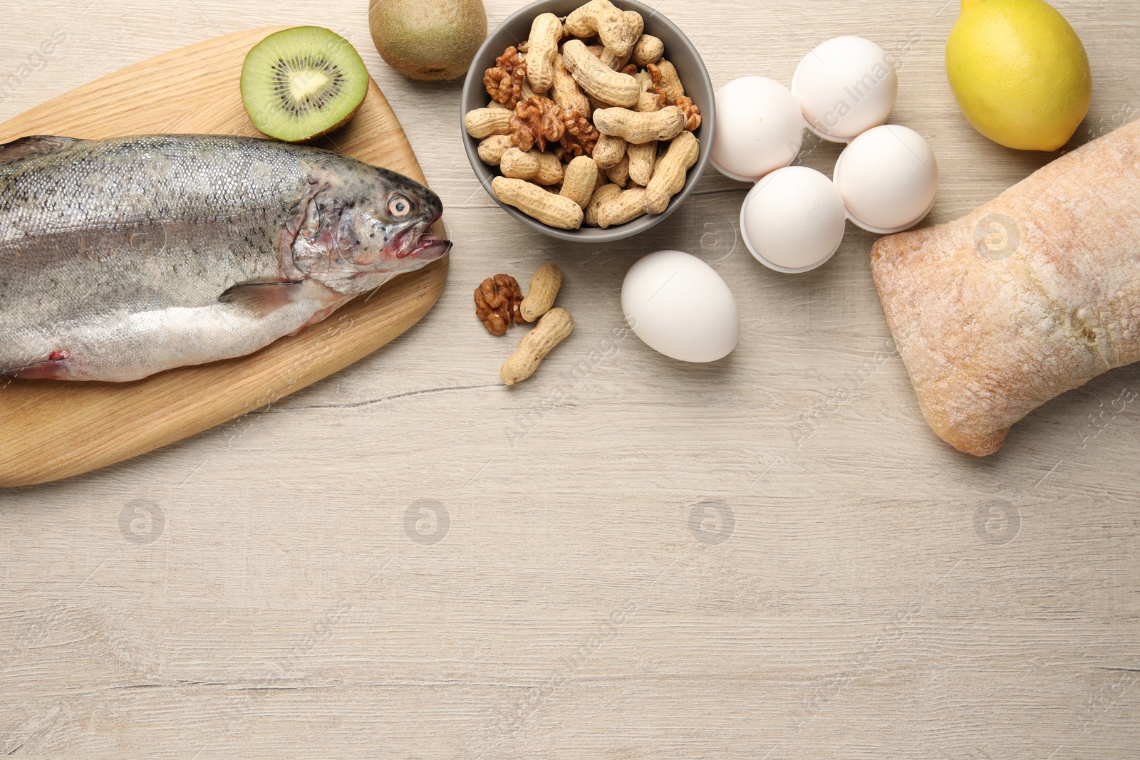 Photo of Allergenic food. Different fresh products on wooden table, flat lay and space for text