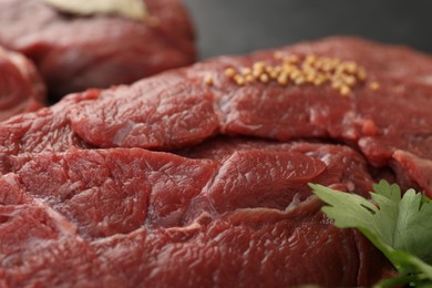 Photo of Piece of raw beef meat with parsley against blurred background, closeup