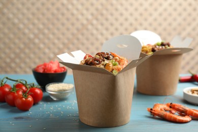 Photo of Boxes of wok noodles with seafood on light blue wooden table