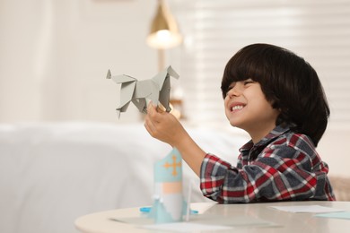 Photo of Cute little boy with paper toy for Saint Nicholas day at home