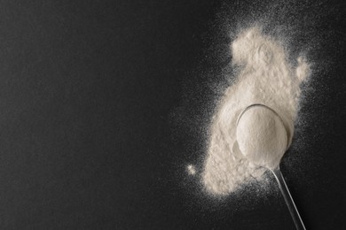 Spoon of agar-agar powder on black background, top view. Space for text