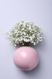 Photo of Bouquet of white gypsophila in ceramic vase on light background, top view