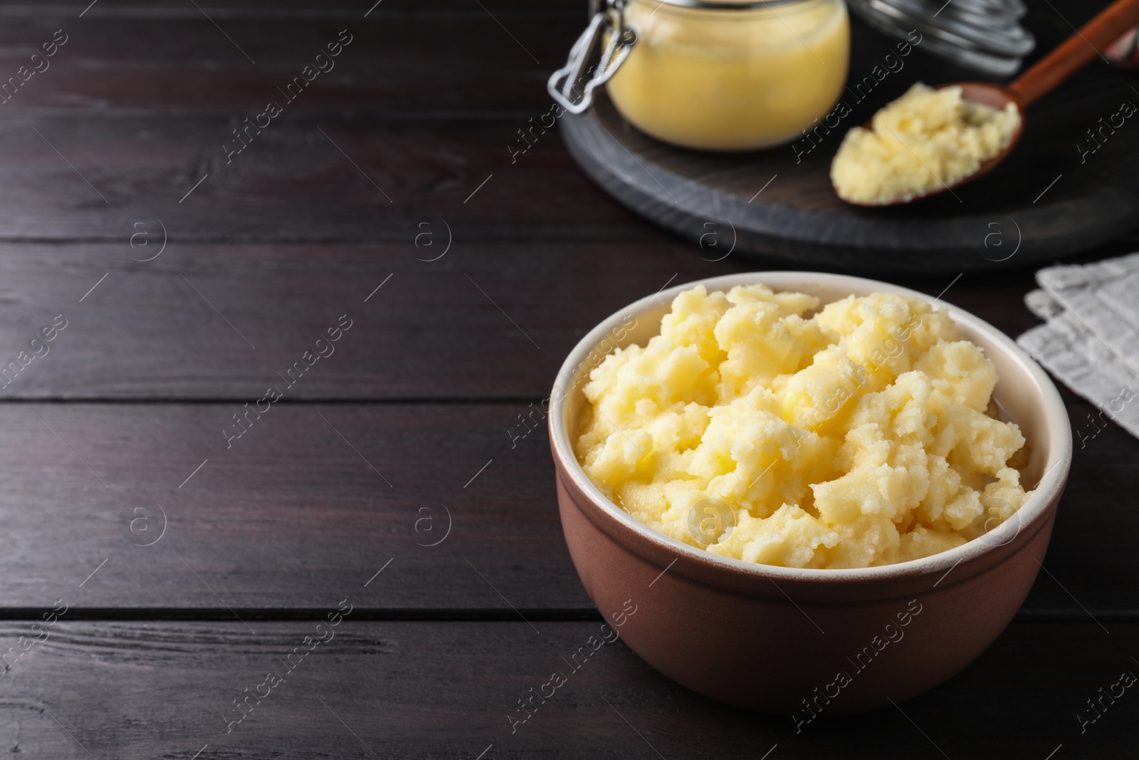 Photo of Bowl of Ghee butter on wooden table. Space for text