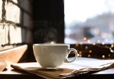 Delicious morning coffee and newspaper near brick wall, indoors