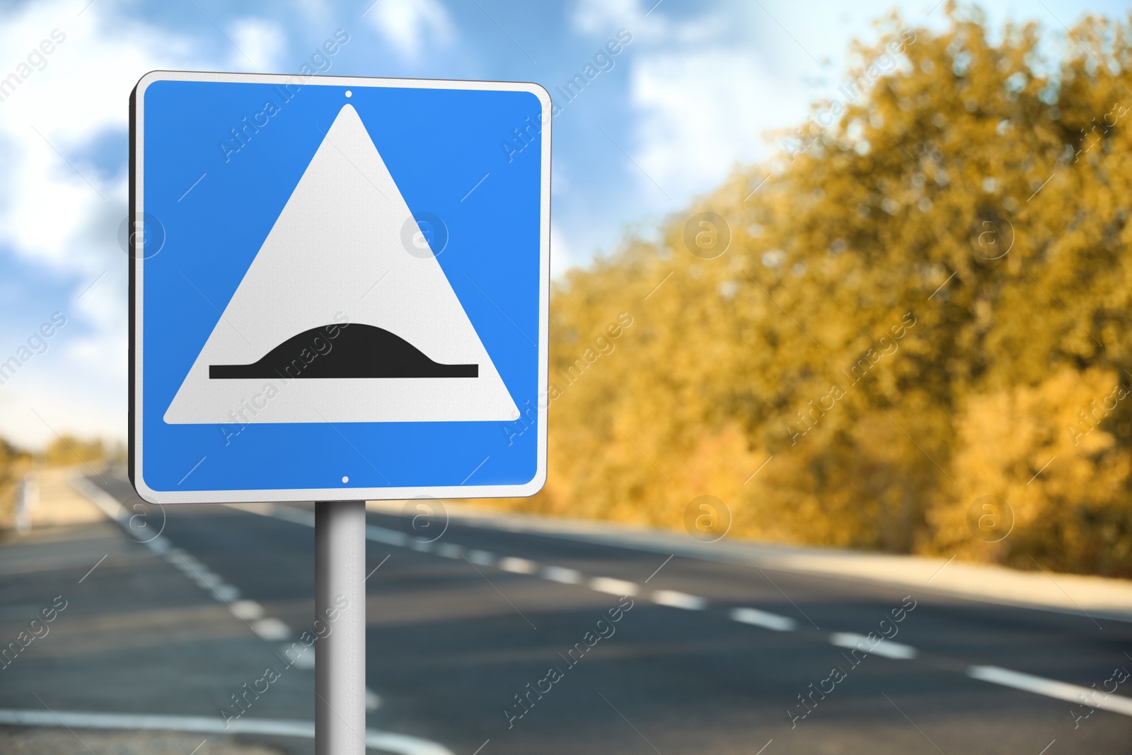 Image of Sign Speed Bump near asphalt road outdoors 