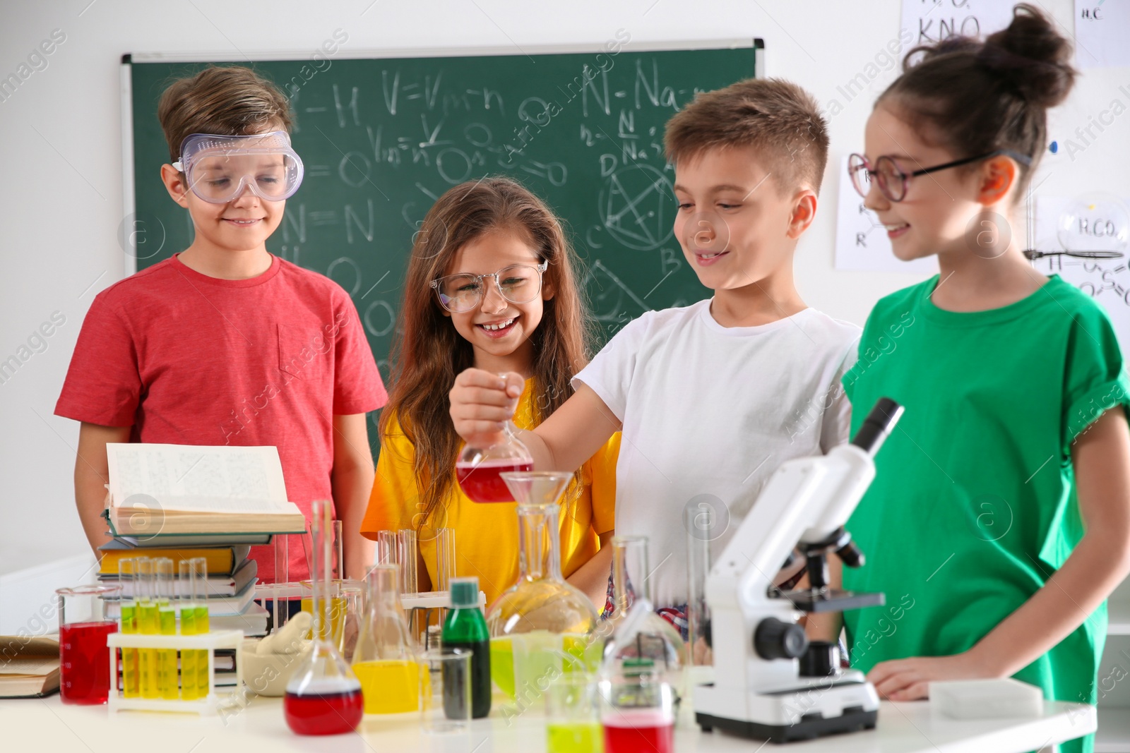 Photo of Smart pupils making experiment in chemistry class