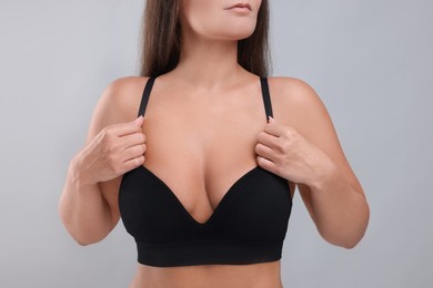 Photo of Woman with beautiful breast on light grey background, closeup