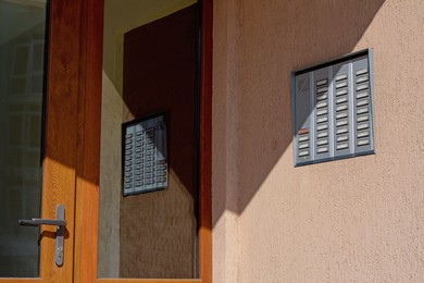 Wall with intercom outdoors on sunny day, space for text