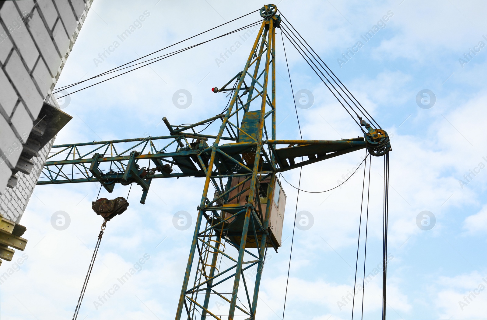 Photo of Construction site with tower crane under beautiful cloudy sky, low angle view