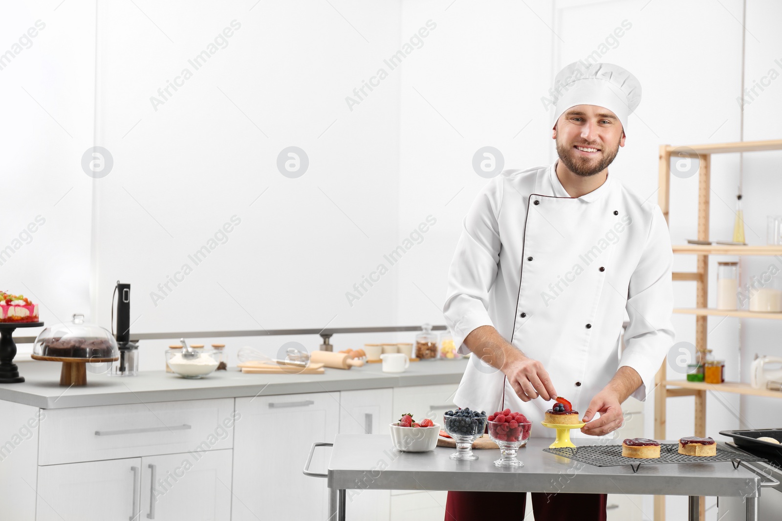 Photo of Male pastry chef preparing dessert at table in kitchen