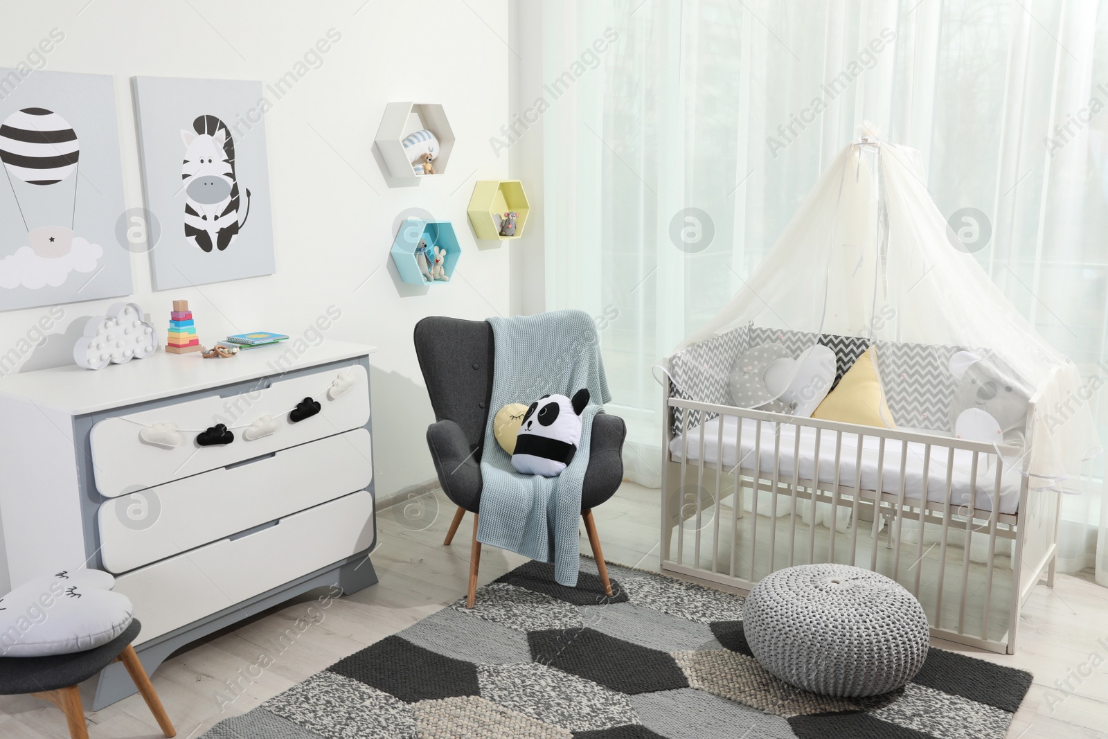 Photo of Cozy baby room with crib and other furniture. Interior design