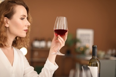 Photo of Woman with glass of delicious wine indoors