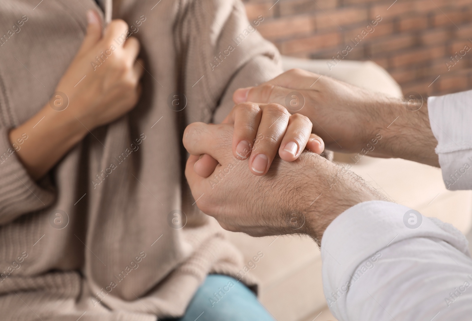 Photo of Man holding woman's hand indoors, closeup. Concept of support and help