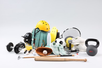 Photo of Many different sports equipment on light grey background
