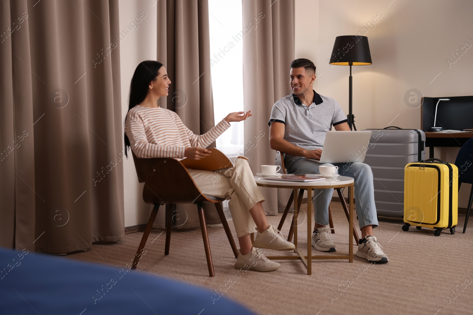 Photo of Happy couple spending time together in hotel room