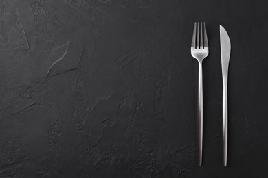 Beautiful cutlery set on black table, flat lay. Space for text