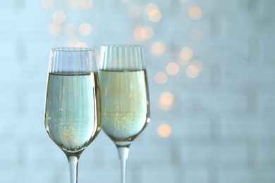 Photo of Glasses of champagne against blurred lights. Space for text