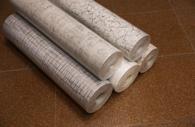 Photo of Different wall paper rolls on floor indoors
