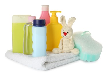 Bottles of baby cosmetic products, bath sponge, towel and toy bunny on white background