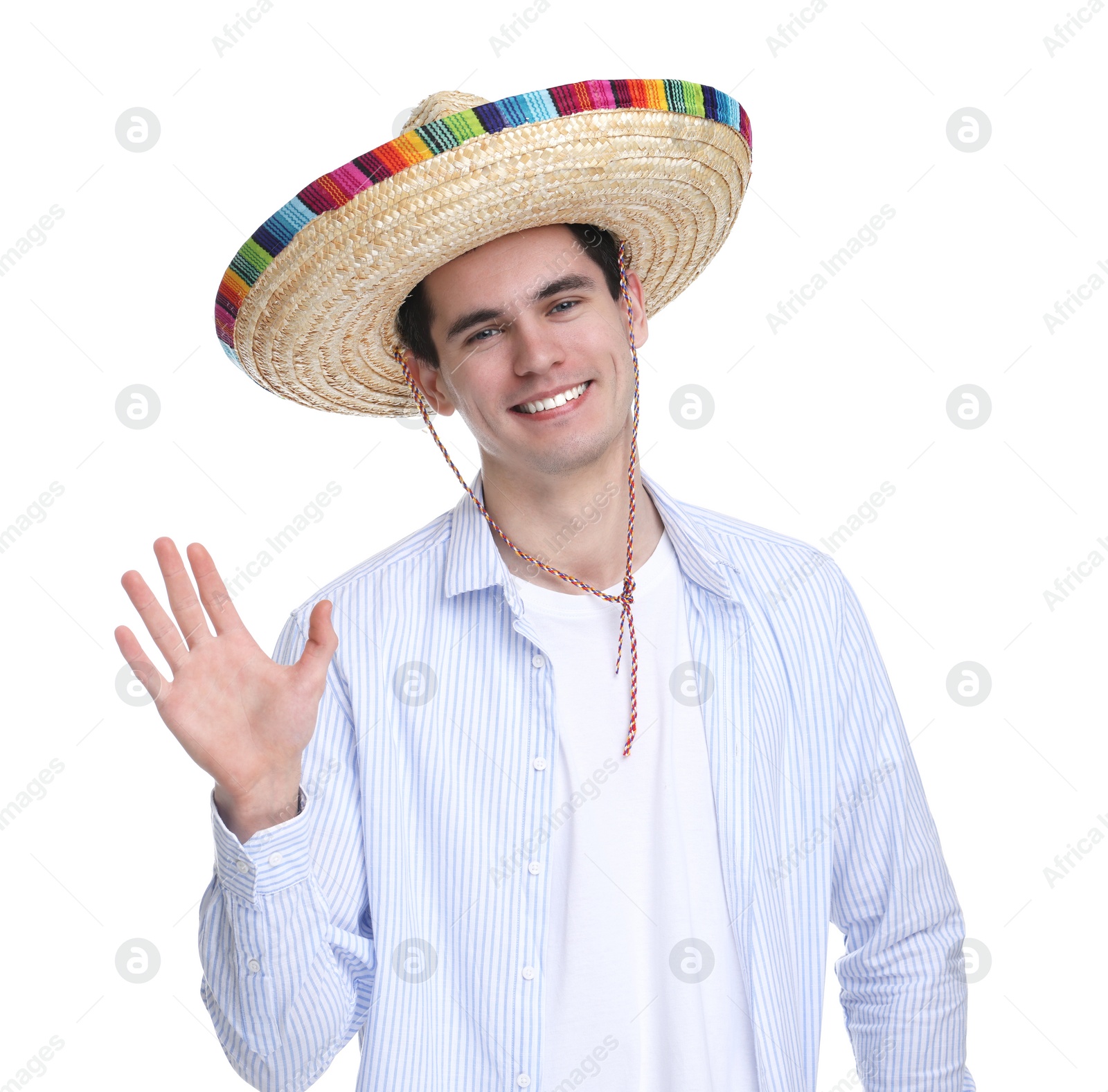 Photo of Young man in Mexican sombrero hat waving hello on white background