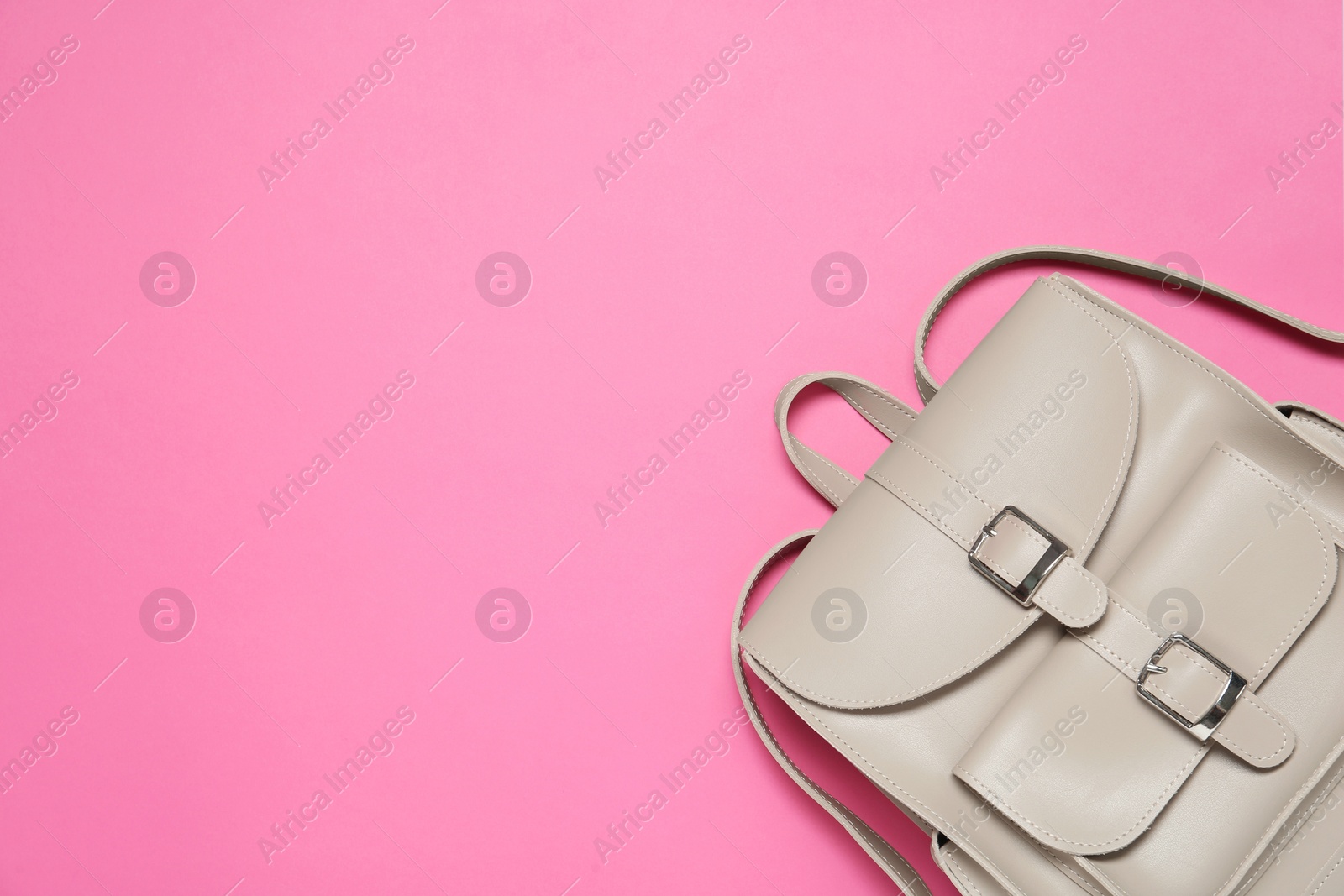 Photo of Stylish urban backpack on pink background, top view. Space for text