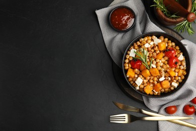 Photo of Delicious fresh chickpea salad served on black table, flat lay. Space for text