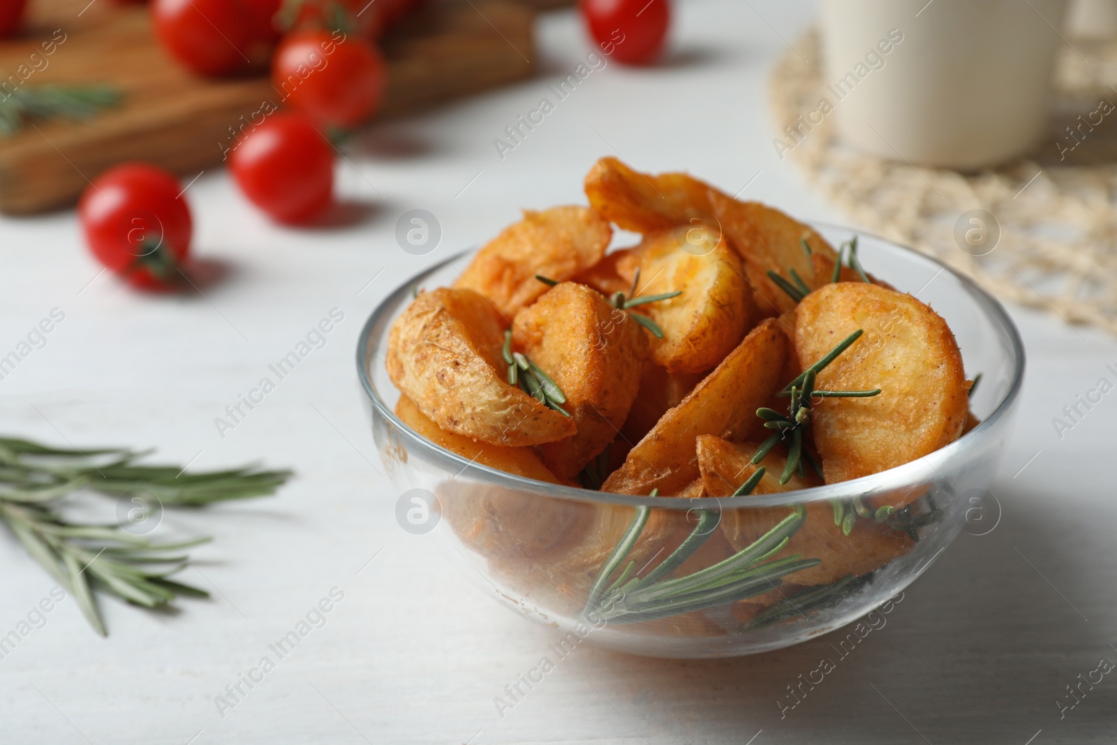 Photo of Baked potatoes with rosemary in bowl on table