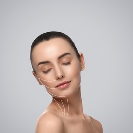 Image of Attractive woman with perfect skin after cosmetic treatment on grey background. Lifting arrows on her face