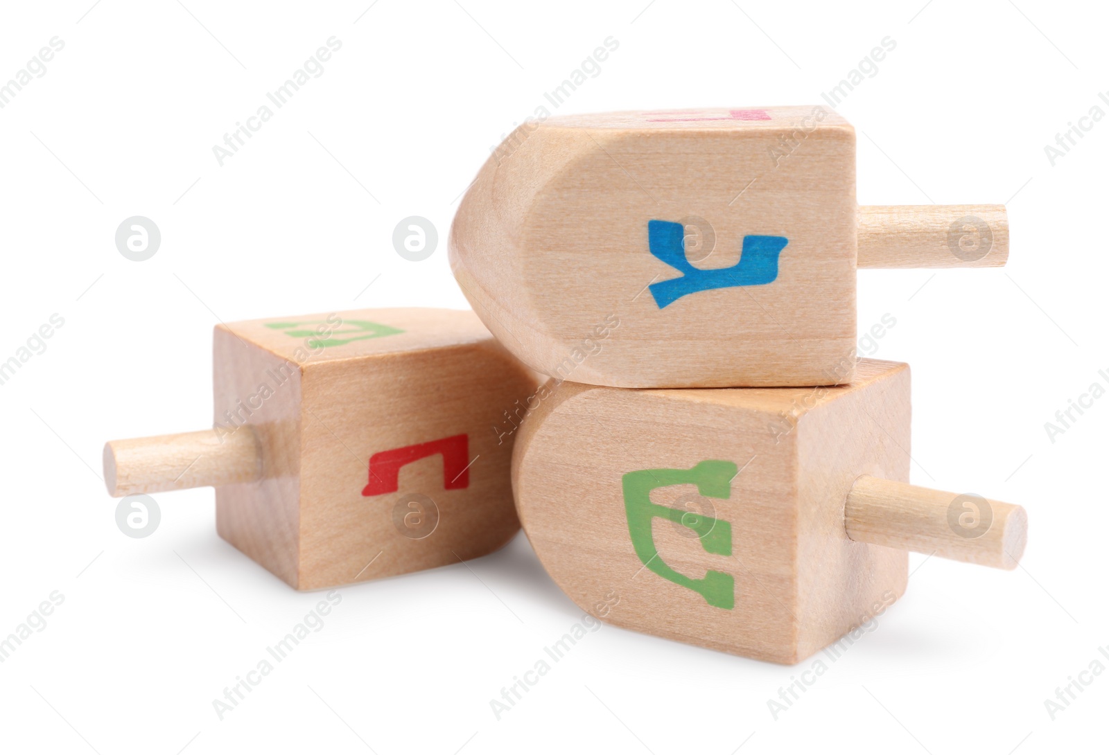 Photo of Hanukkah celebration. Wooden dreidels with jewish letters isolated on white