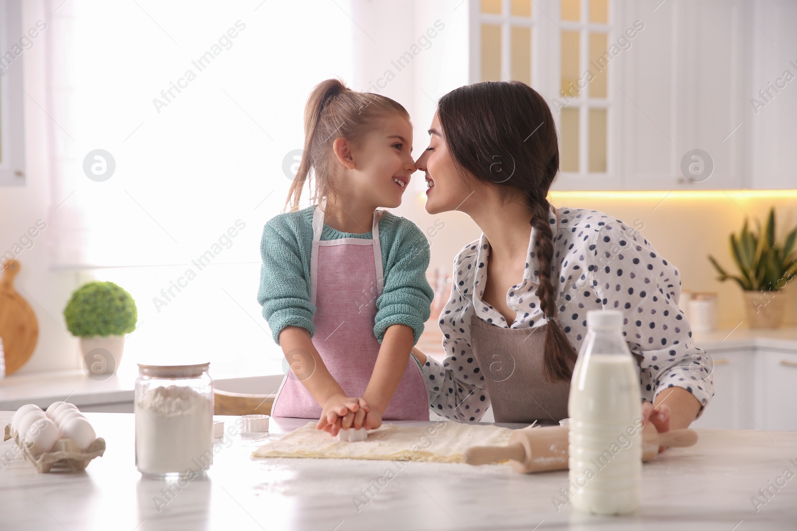 Photo of Mother and daughter making pastry in kitchen at home