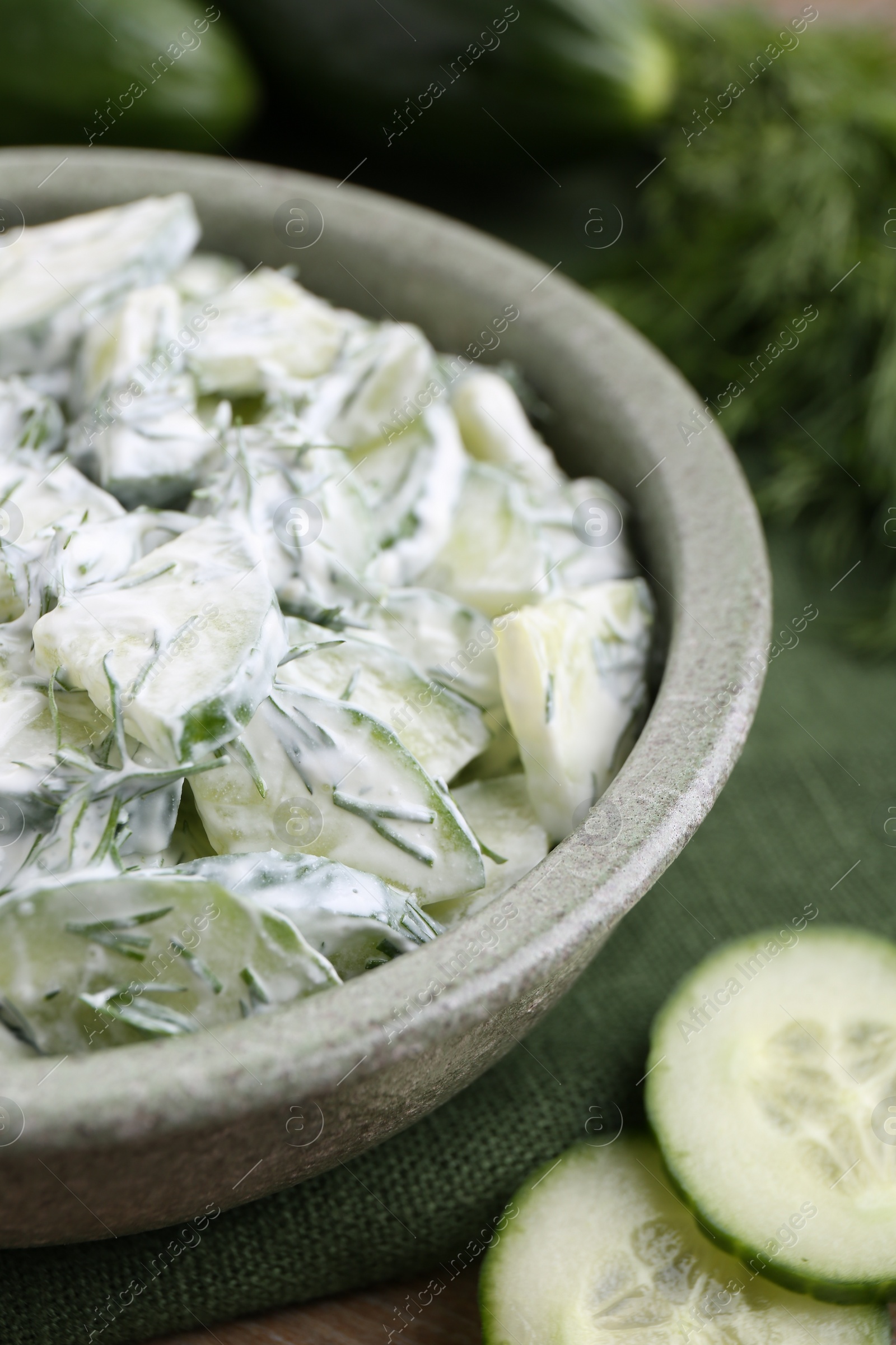 Photo of Delicious cucumber salad in bowl on table, closeup