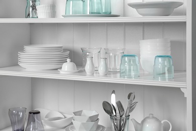 Photo of White shelving unit with set of dishware