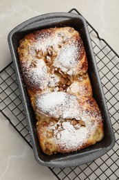 Delicious yeast dough cake in baking pan on marble table, top view