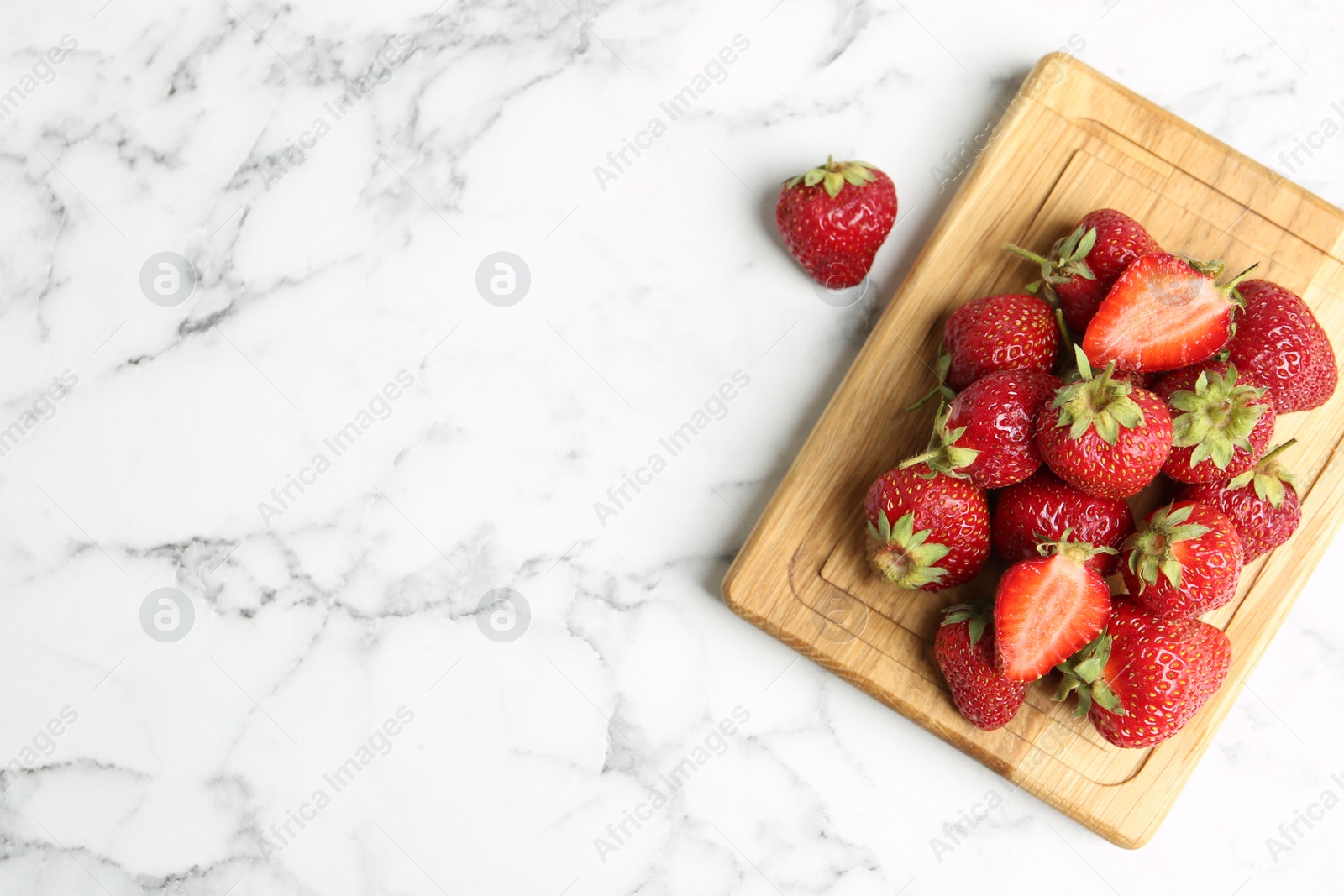 Photo of Delicious ripe strawberries on white marble table, flat lay. Space for text